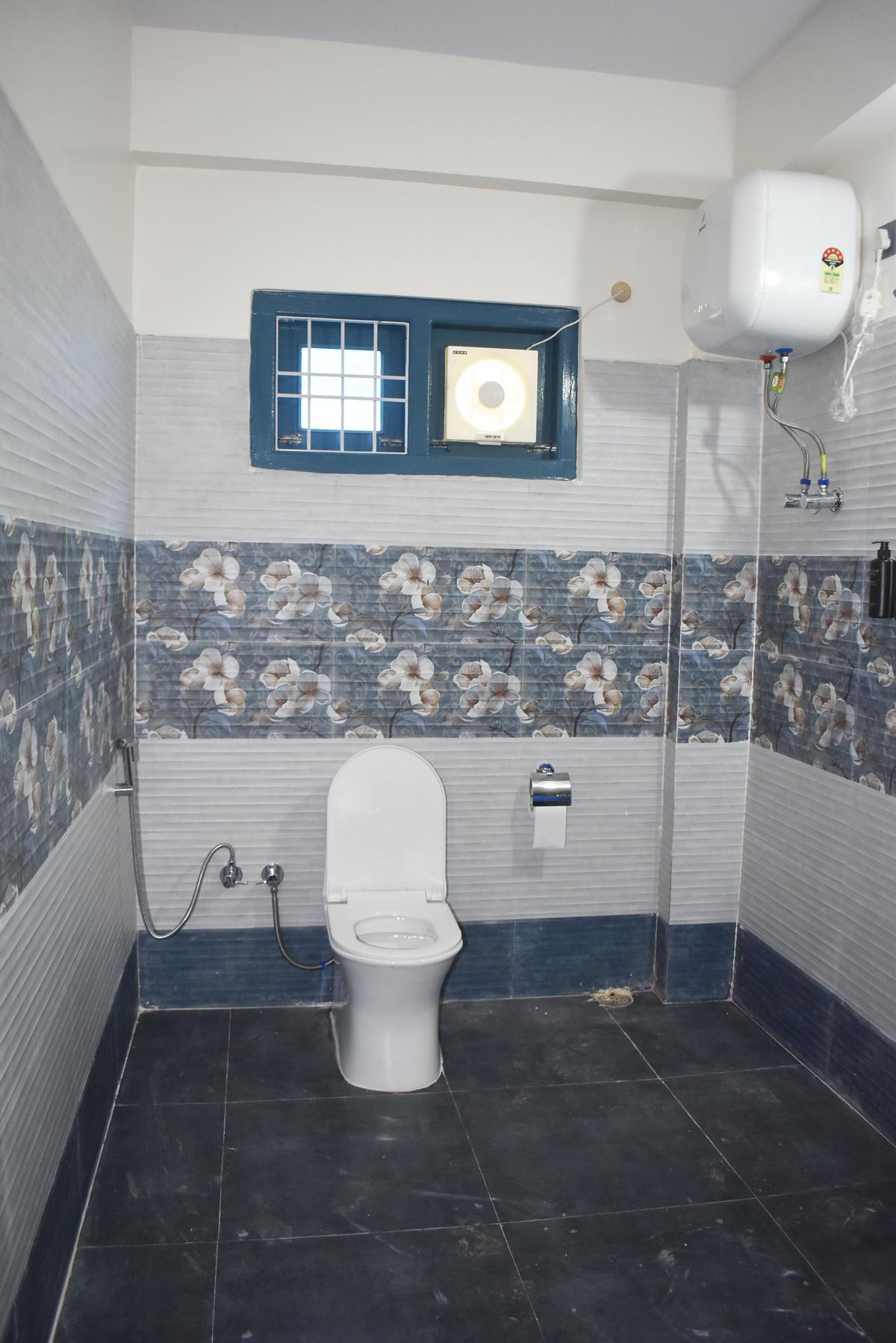 Bathroom with modern tiles and geyser at Hotel Pema Lhatse Dirang