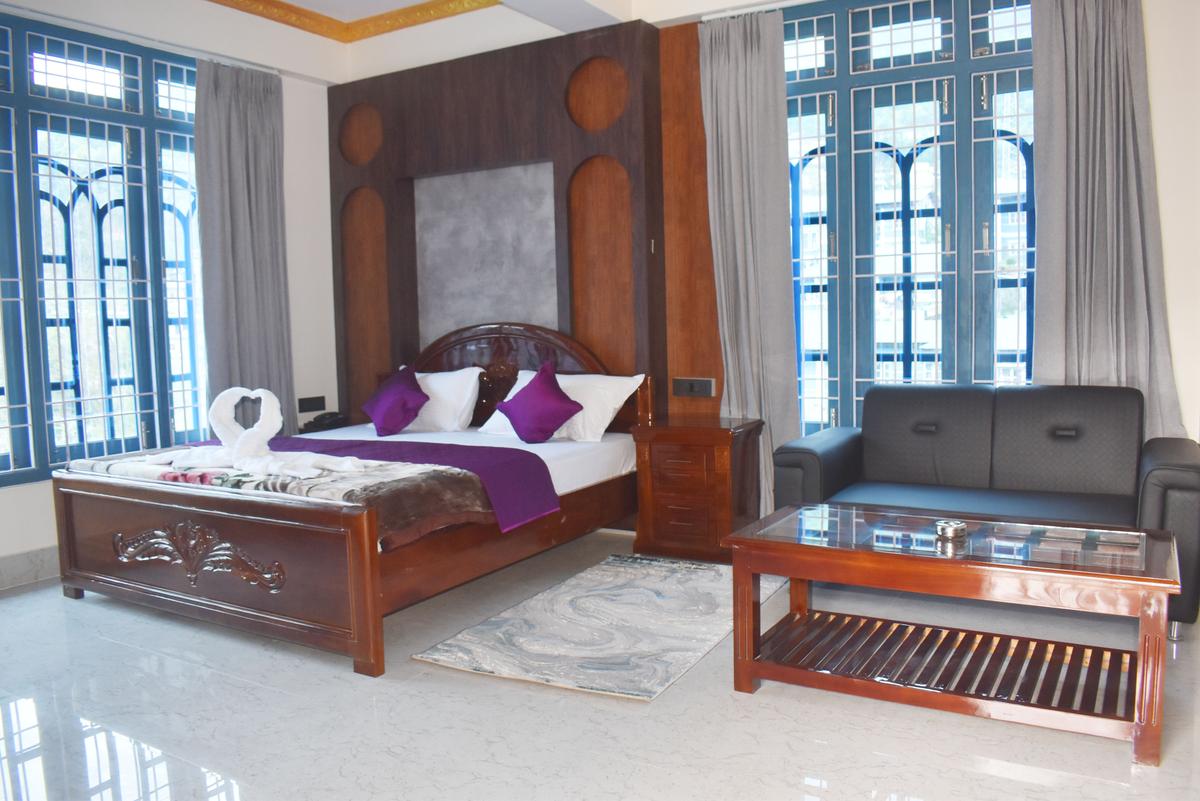 Premium Suite at Hotel Pema Lhatse Dirang with designer headboard, purple bedding, leather sofa, Rs 7000 per night