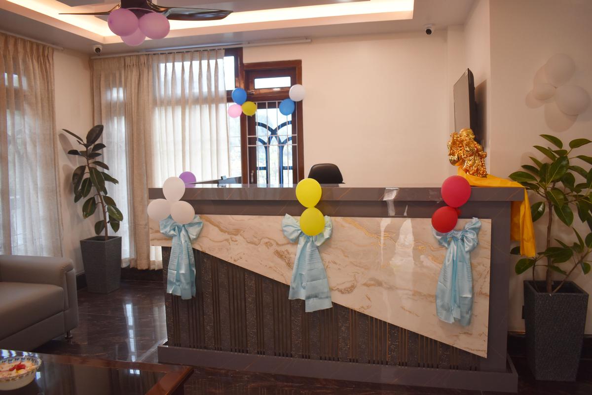 Hotel Pema Lhatse reception desk with marble counter, golden statue and plants