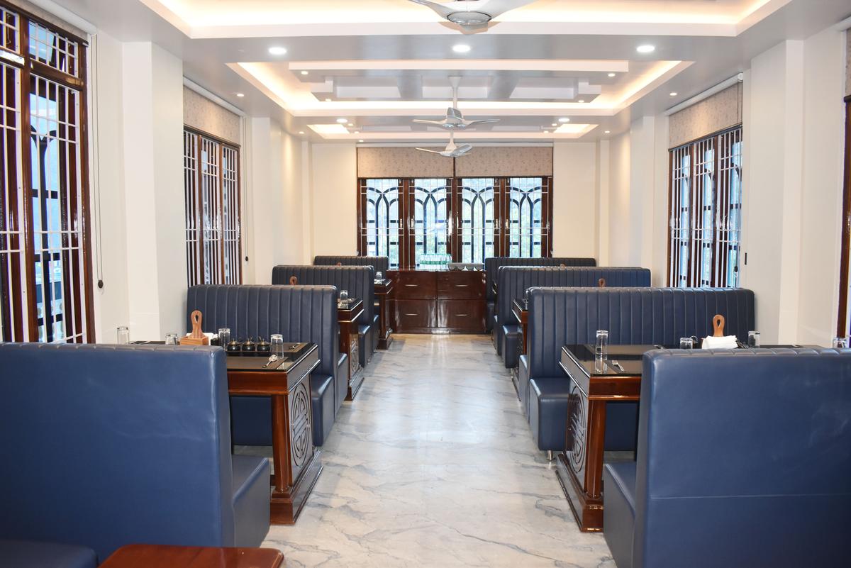 Hotel Pema Lhatse restaurant full interior view with booth seating, marble floors, ceiling lights in Dirang